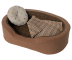 A toy dog bed with a pillow and a blanket.